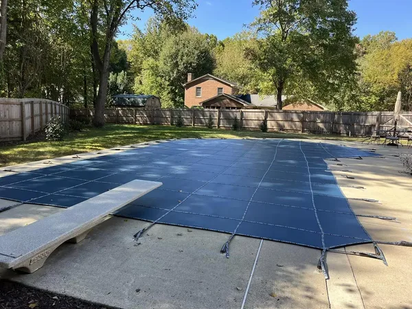 Blue LOOP-LOC mesh safety cover over a rectangular pool